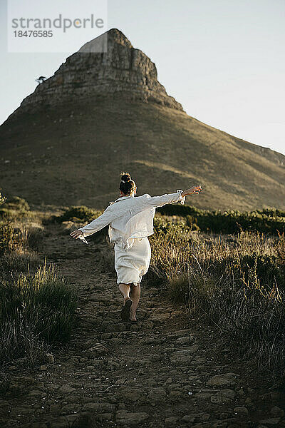 Frau rennt bei Sonnenuntergang auf den Berg Lion's Head zu