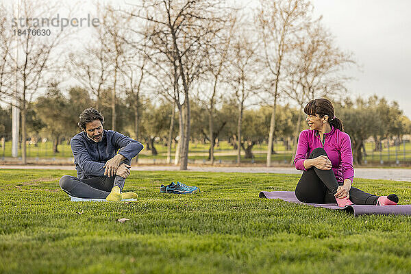 Glückliches älteres Paar  das Yoga im Park praktiziert