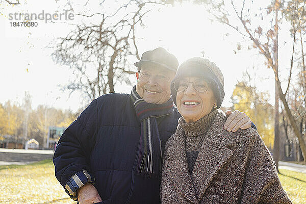 Glückliches älteres Paar im Herbstpark an einem sonnigen Tag