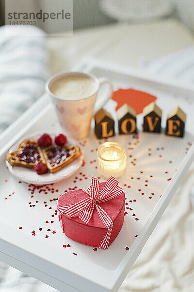 Heart shaped gift box with breakfast on tray