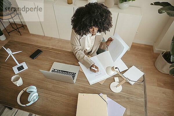 Geschäftsfrau mit Afro-Frisur macht sich im Büro Notizen
