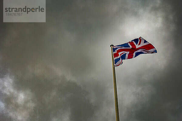 Union Jack-Flagge weht unter Gewitterwolken
