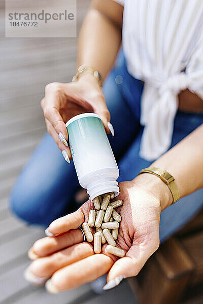 Hands of woman holding capsule pills
