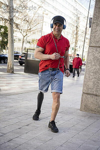 Lächelnder Mann mit Behinderung geht auf Fußweg