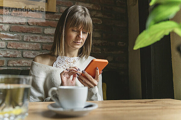 Frau benutzt Smartphone im Café