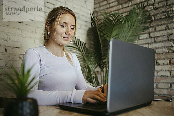 Geschäftsfrau tippt im Büro am Laptop