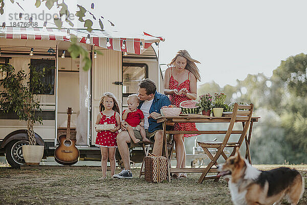 Eltern und Kinder bereiten Picknick-Wohnmobil vor