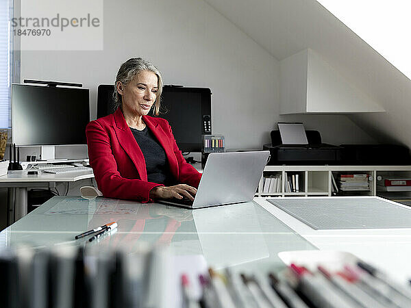 Geschäftsfrau arbeitet am Laptop am Schreibtisch im Büro