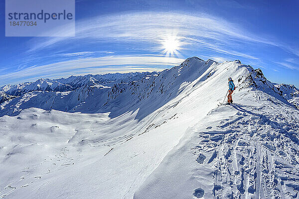 Österreich  Tirol  Sonne scheint über einer Skifahrerin und bewundert die schneebedeckte Landschaft in den Tuxer Alpen