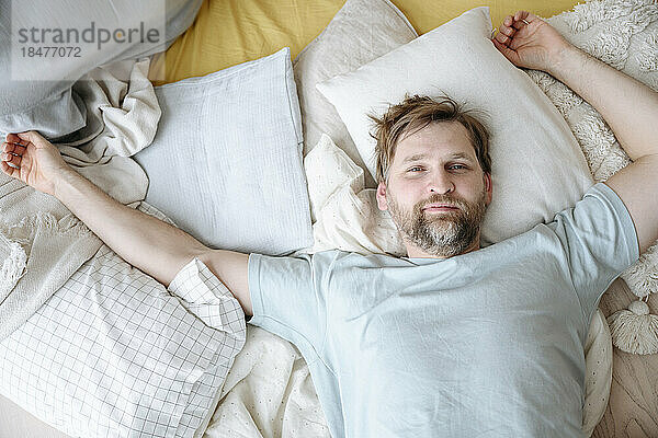 Man waking up on bed at home
