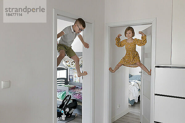 Children climbing doorway at home