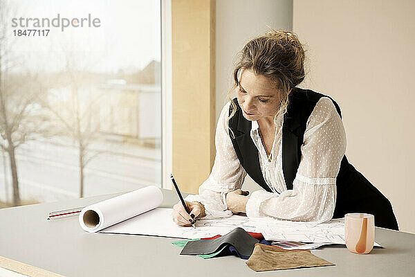 Kreatives professionelles Skizzieren auf Papier mit Bleistift am Tisch