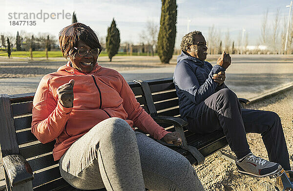 Älteres Paar sitzt auf Bank im Park