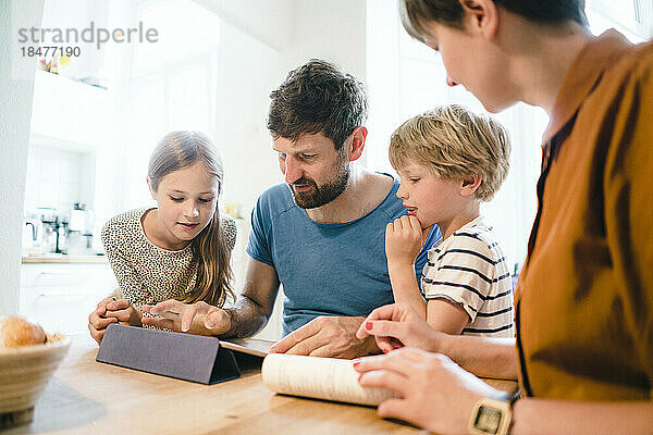 Vater teilt Tablet-PC mit Sohn und Tochter zu Hause
