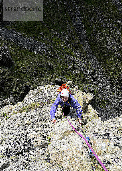 Frau klettert auf Fels am Berg Pillar  Western Fells  Lake District  England