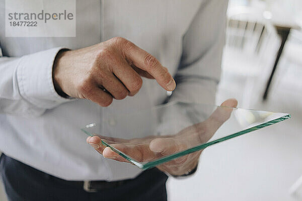 Geschäftsmann mit futuristischem transparentem Tablet-PC