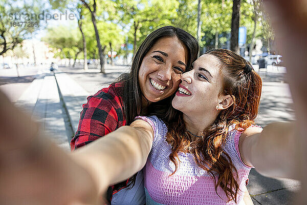 Glückliches lesbisches Paar  das Selfie auf dem Fußweg macht