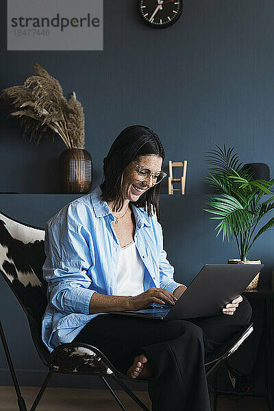 Lächelnde Geschäftsfrau  die zu Hause am Laptop arbeitet