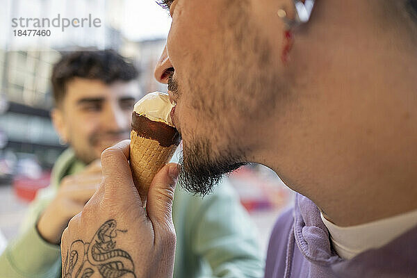 Schwule essen Eis im Straßencafé