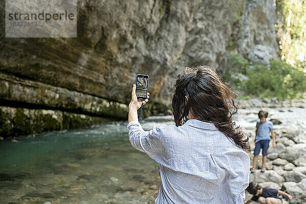 Frau fotografiert im Urlaub die Natur per Smartphone