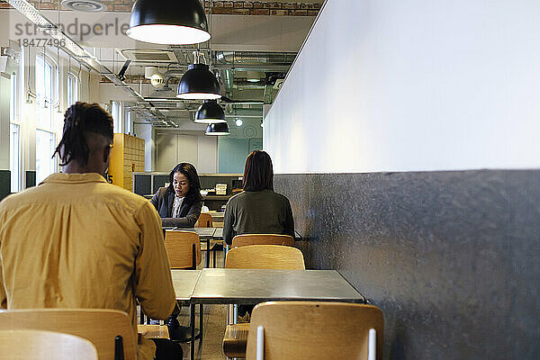 Geschäftskollegen arbeiten in der Cafeteria im Büro zusammen