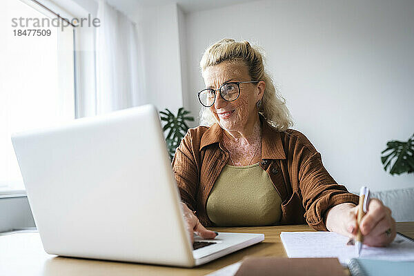 Lächelnde Geschäftsfrau mit Vitiligo-Haut  die im Heimbüro arbeitet