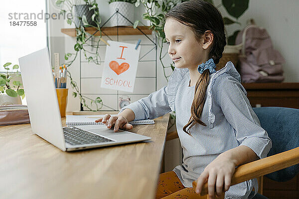 Lächelndes Mädchen  das zu Hause Laptop benutzt