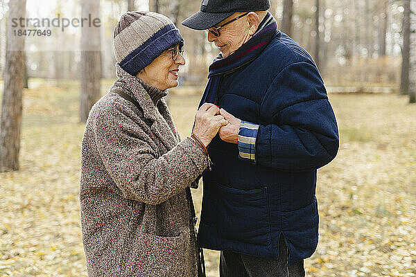 Älteres Paar hält Händchen und steht im Park