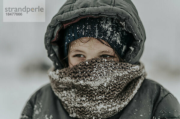 Junge trägt Schal im Schnee