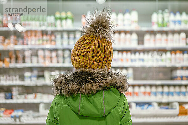 Junge trägt Parka-Mantel im Geschäft