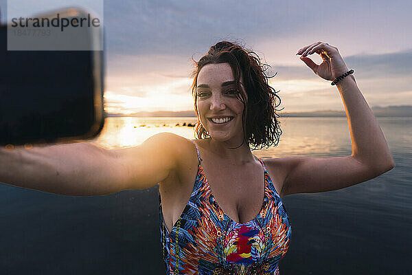 Glückliche Frau  die am Strand ein Selfie mit dem Smartphone macht