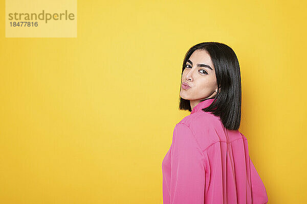 Beautiful woman posing against yellow background