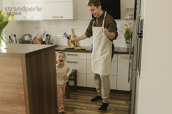 Vater und Tochter amüsieren sich zu Hause in der Küche