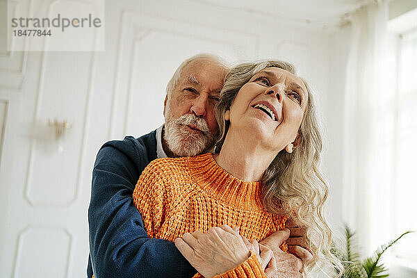 Glückliches älteres Paar  das sich zu Hause umarmt