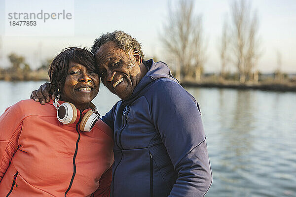 Glückliches älteres Paar vor dem See bei Sonnenuntergang