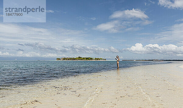 Junge Frau steht im Wasser am Strand  Pontod Island  Philippinen