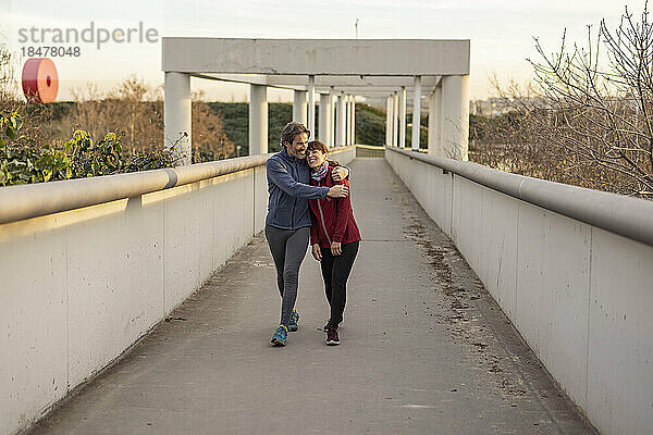 Glücklicher reifer Mann umarmt Frau auf Brücke