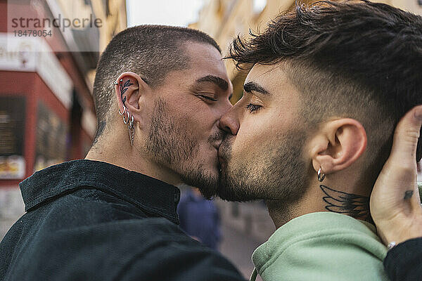 Romantisches schwules Paar küsst sich vor dem Gebäude