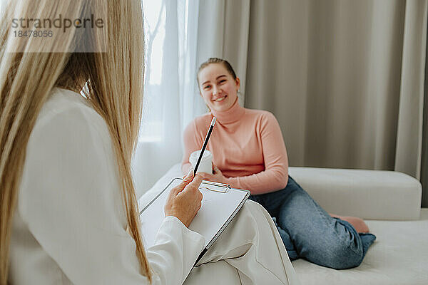 Lächelnder Patient diskutiert mit Psychologe in der Klinik