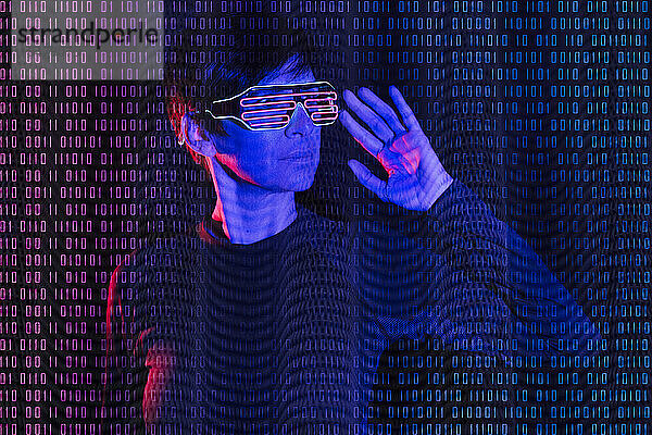 Reife Frau trägt eine futuristische Brille mit Binärcode
