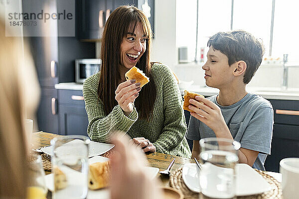 Glückliche Frau mit Sohn beim Frühstück zu Hause