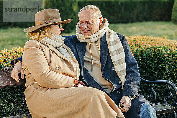 Älteres Paar redet miteinander und sitzt auf einer Bank