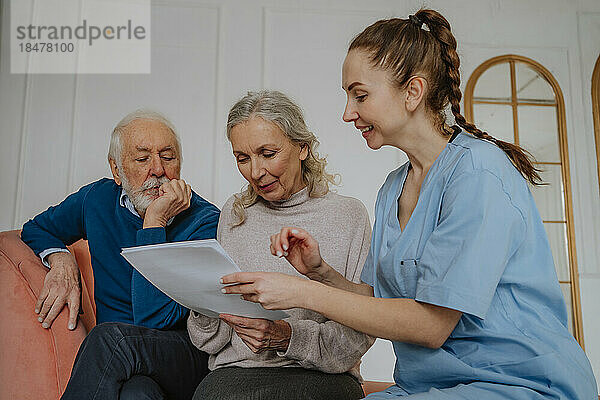 Ältere Patienten lesen medizinische Berichte von der Krankenschwester zu Hause