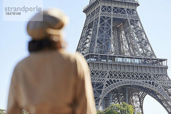Frau blickt an einem sonnigen Tag auf den Eiffelturm  Paris  Frankreich