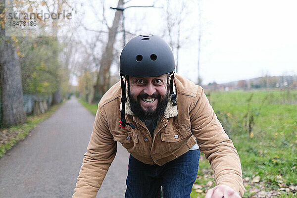 Glücklicher Mann mit Helm auf der Straße