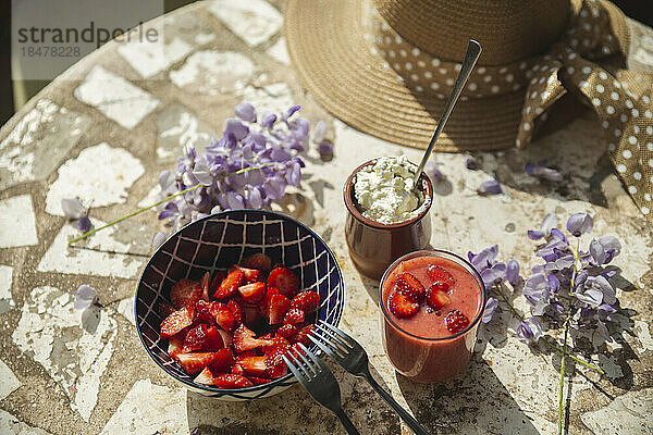 Erdbeeren mit Sahne und Saft auf dem Tisch