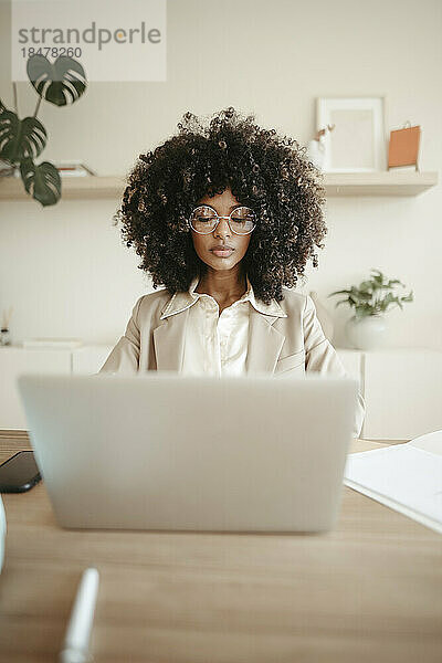 Geschäftsfrau mit Brille und Laptop im Büro