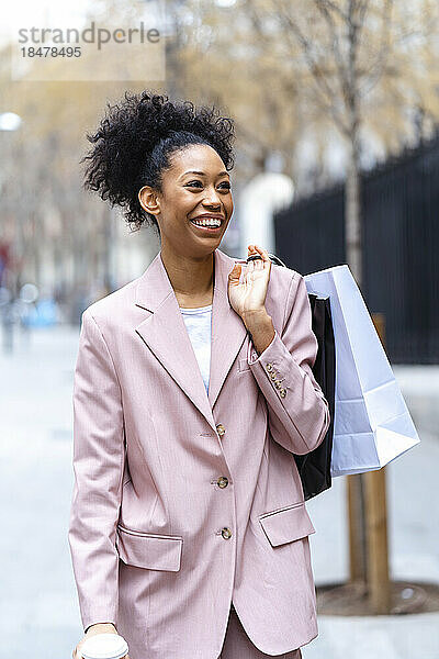 Glückliche junge Geschäftsfrau mit Einkaufstüten