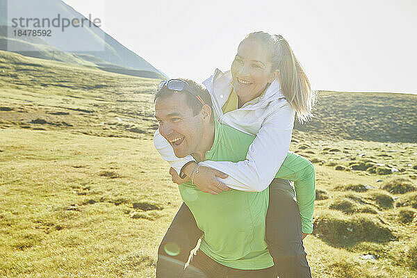 Austria  Tyrol  Male hiker piggybacking young woman