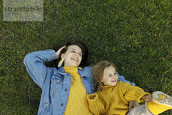 Glückliche Mutter und Tochter liegen auf Gras im Park